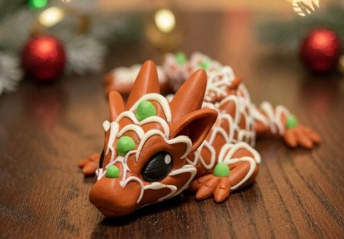 Gingerbread dragon decoration on a wooden surface with Christmas ornaments in the background