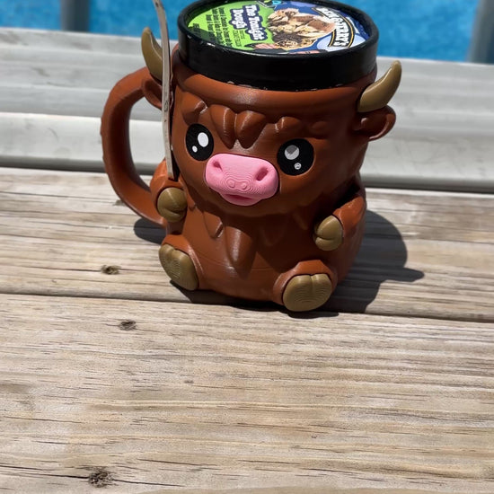 3D-printed Highland Cow pint holder with shaggy texture; Cozy brown cow pint cozy on rustic table with flowers
